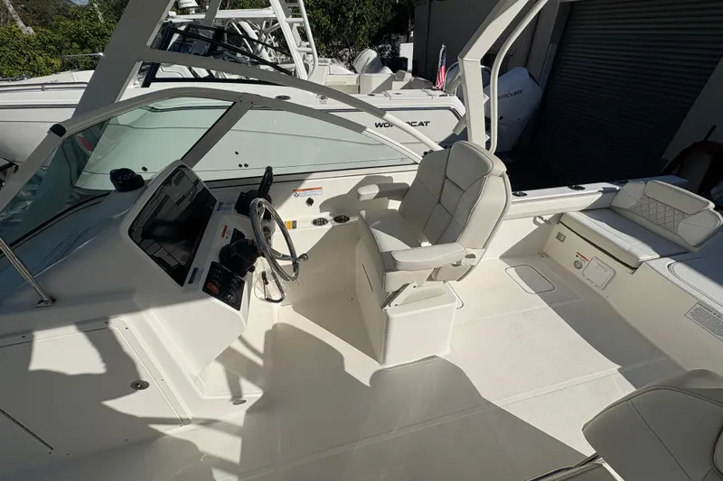  Yacht Photos Pics 2025 World Cat 230 DC boat interior with steering wheel and seating area.