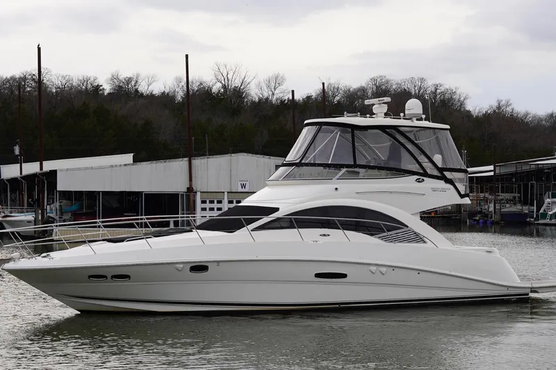  Yacht Photos Pics 2009 Sea Ray 47 Sedan Bridge yacht docked at a marina, overcast sky.