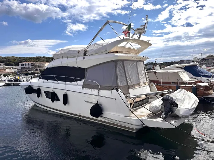 Pure Yacht Photos Pics 2016 Prestige 500 yacht docked in a marina under a partly cloudy sky.