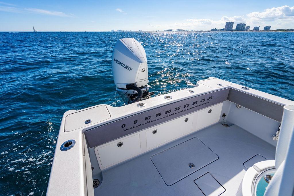 2026 Reef Runner 230 boat with Mercury engine on sparkling ocean water.