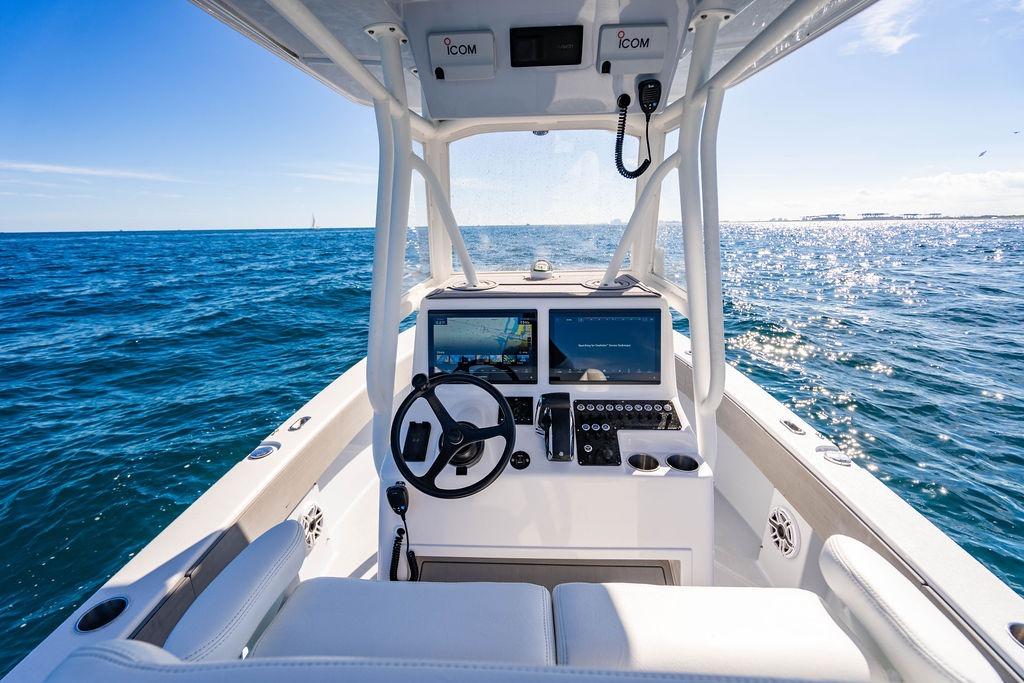 Helm of 2026 Reef Runner 230 boat with ocean view and modern controls.