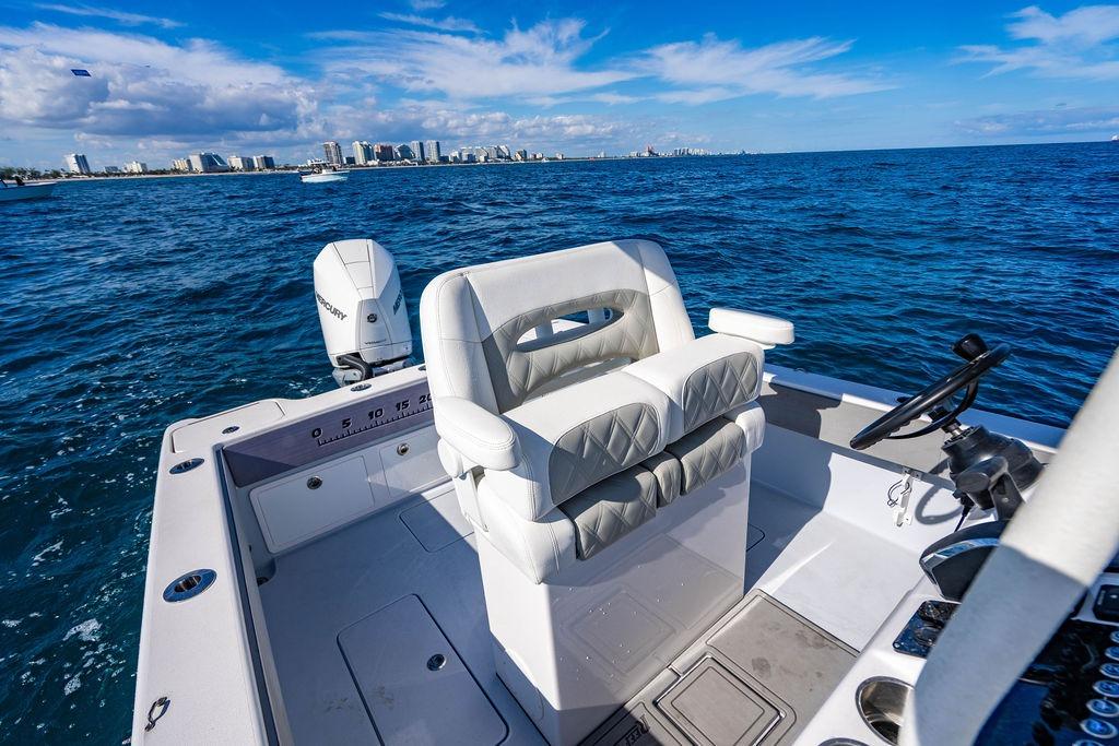 Reef Runner 230 boat, 2026 model, on open sea with city skyline.