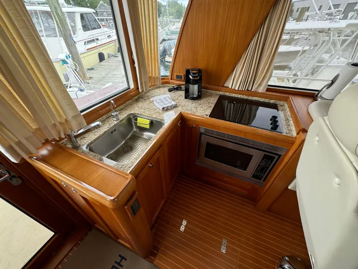 Hezitation Yacht Photos Pics Luxurious 2009 Grand Banks 45 Eastbay SX yacht kitchen with modern amenities and wood finish.