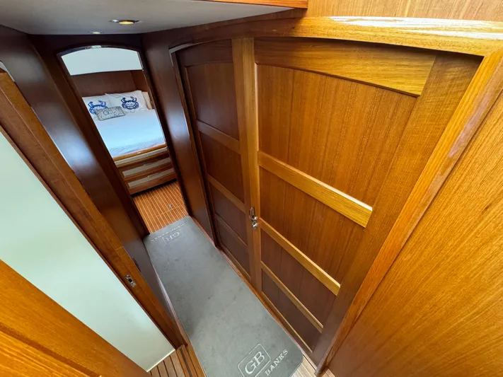 Hezitation Yacht Photos Pics Wood-paneled hallway inside 2009 Grand Banks 45 Eastbay SX yacht, leading to a cozy bedroom.