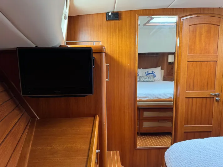 Hezitation Yacht Photos Pics Interior of 2009 Grand Banks 45 Eastbay SX with wood paneling, TV, and mirror.