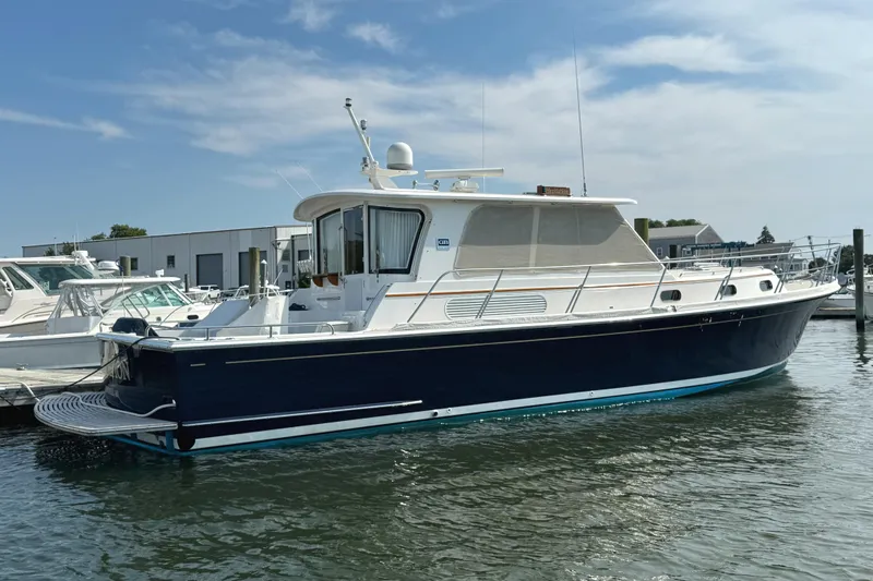 Hezitation Yacht Photos Pics 2009 Grand Banks 45 Eastbay SX yacht docked in a marina under a clear sky.