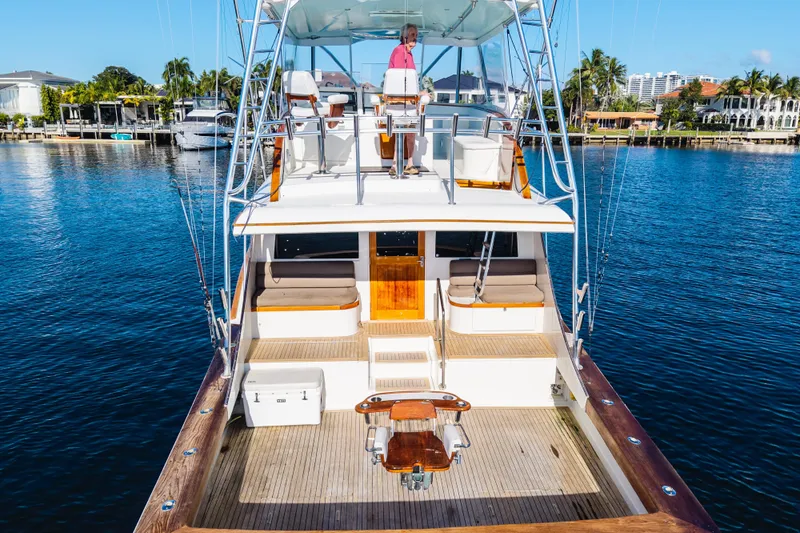 Cherin III Yacht Photos Pics Luxury B&D 65 Flybridge yacht, 2004 model, docked in a serene marina setting.