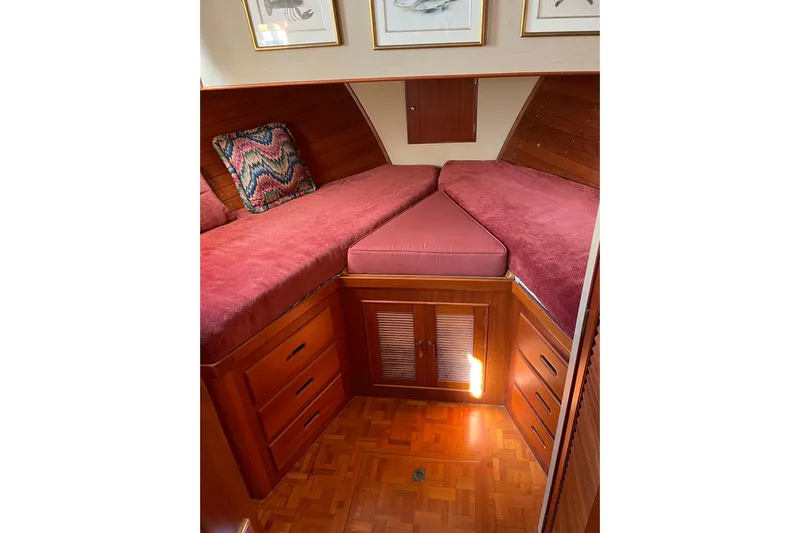 Daddy's Dream Yacht Photos Pics Cozy cabin interior of 1991 Grand Banks 46 Motoryacht with red bedding and wooden cabinetry.