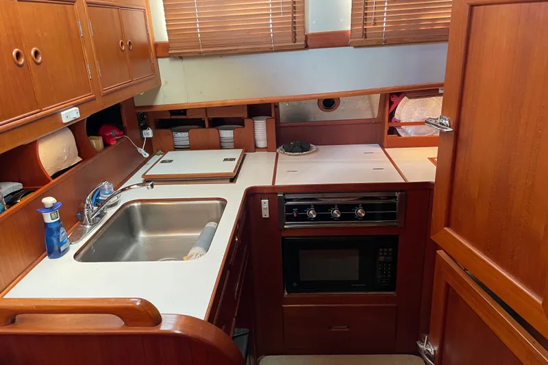 Daddy's Dream Yacht Photos Pics 1991 Grand Banks 46 Motoryacht kitchen with sink, stove, and wooden cabinetry.