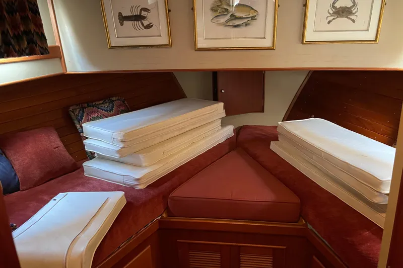 Daddy's Dream Yacht Photos Pics Cozy cabin interior of 1991 Grand Banks 46 Motoryacht with stacked cushions and marine decor.