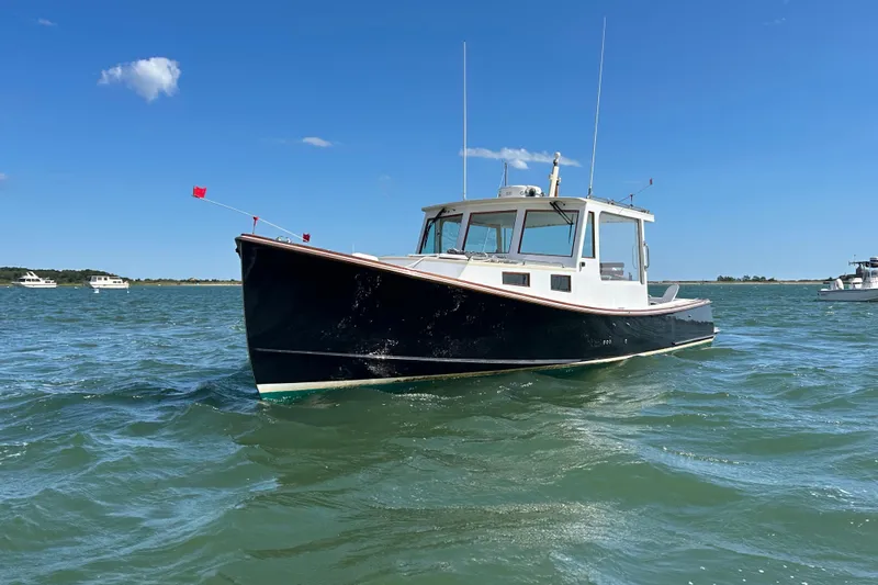 Nellie Yacht Photos Pics 1995 Holland Pettegrow Cruiser on open water under clear blue sky.