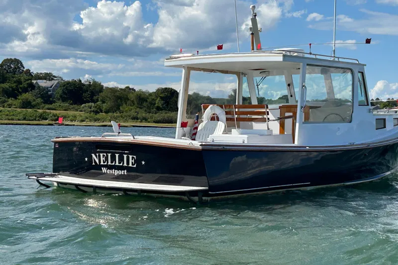 Nellie Yacht Photos Pics 1995 Holland Pettegrow Cruiser "Nellie" on water, scenic background, clear sky.