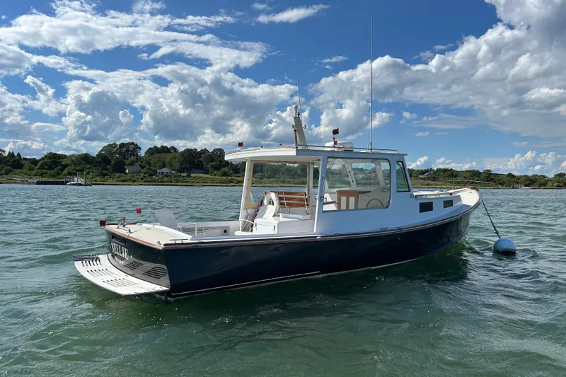 Nellie Yacht Photos Pics 1995 Holland Pettegrow Cruiser on water, blue sky, scenic background.