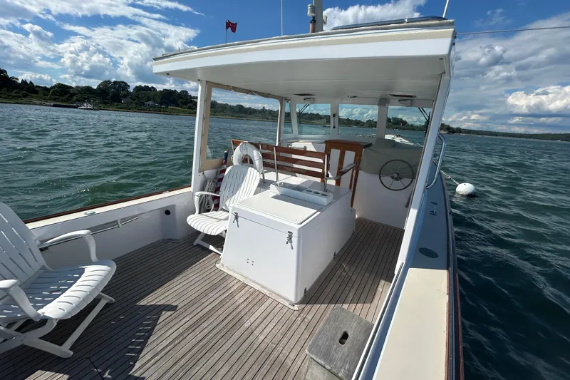 Nellie Yacht Photos Pics 1995 Holland Pettegrow Cruiser on water, featuring deck chairs and steering wheel.