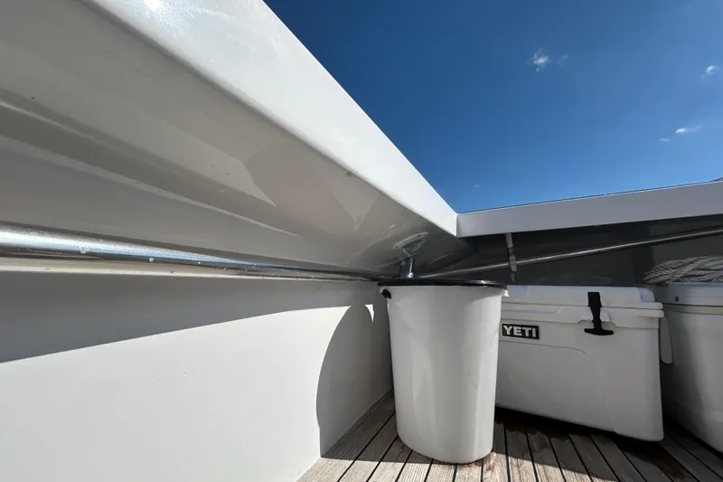 Nellie Yacht Photos Pics 1995 Holland Pettegrow Cruiser deck with Yeti cooler and trash bin under clear blue sky.
