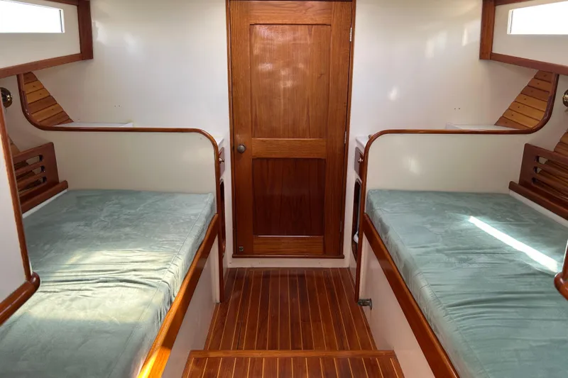 Nellie Yacht Photos Pics Interior of 1995 Holland Pettegrow Cruiser with twin beds and wooden finishes.