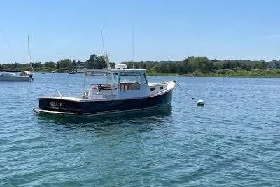 Nellie Yacht Photos Pics 1995 Holland Pettegrow Cruiser on calm water, clear sky, and scenic background.