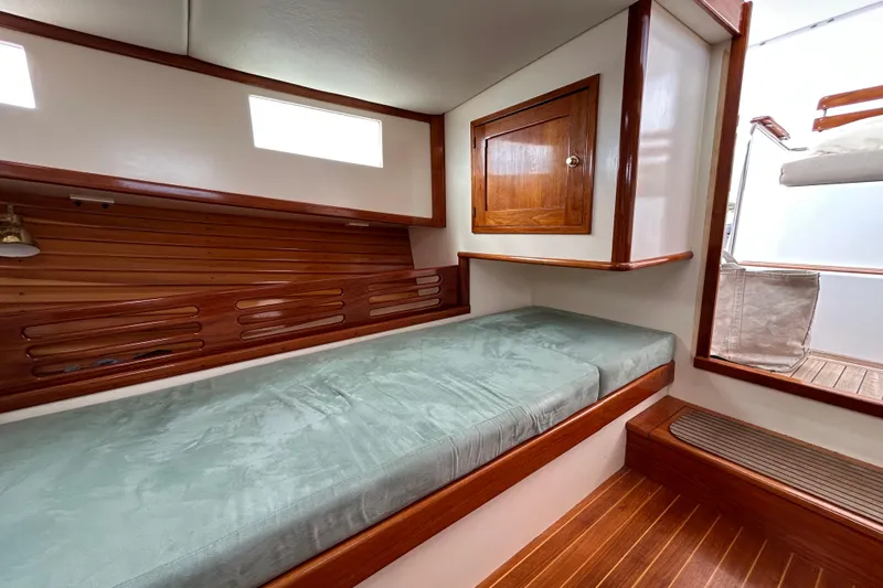 Nellie Yacht Photos Pics Luxurious 1995 Holland Pettegrow Cruiser cabin with wooden accents and comfortable bedding.