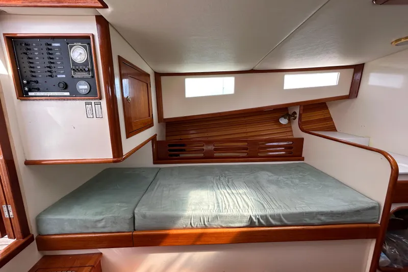 Nellie Yacht Photos Pics Interior of 1995 Holland Pettegrow Cruiser with bed, control panel, and wooden accents.