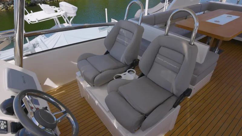  Yacht Photos Pics Luxury helm seating on 2014 Fairline Squadron 78 Custom yacht, featuring plush gray upholstery.