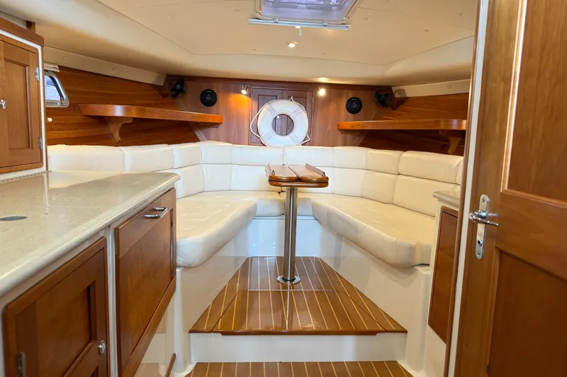 Kikiriki Yacht Photos Pics Luxurious interior of 2007 MJM 34z Downeast yacht with white seating and wooden accents.