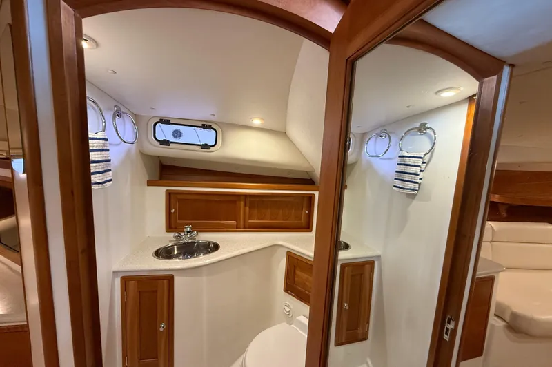 Kikiriki Yacht Photos Pics 2007 MJM 34z Downeast yacht interior with wooden cabinetry and compact bathroom.