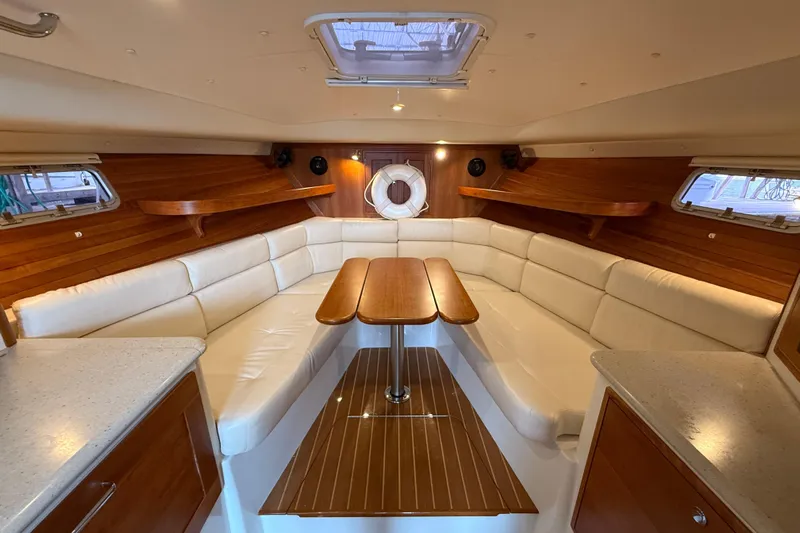 Kikiriki Yacht Photos Pics Luxurious interior of 2007 MJM 34z Downeast yacht with elegant wood and white seating.