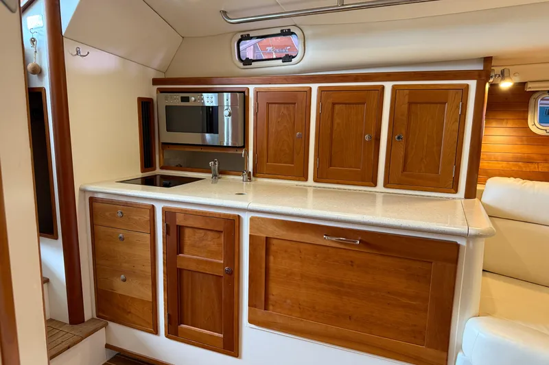 Kikiriki Yacht Photos Pics 2007 MJM 34z Downeast yacht interior kitchen with wooden cabinets and modern appliances.