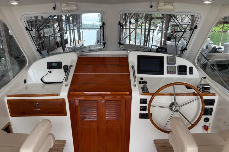 Kikiriki Yacht Photos Pics Helm of 2007 MJM 34z Downeast boat with wooden accents and modern controls.