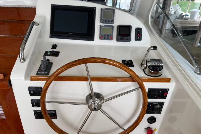 Kikiriki Yacht Photos Pics Helm of 2007 MJM 34z Downeast boat with wooden steering wheel and navigation controls.