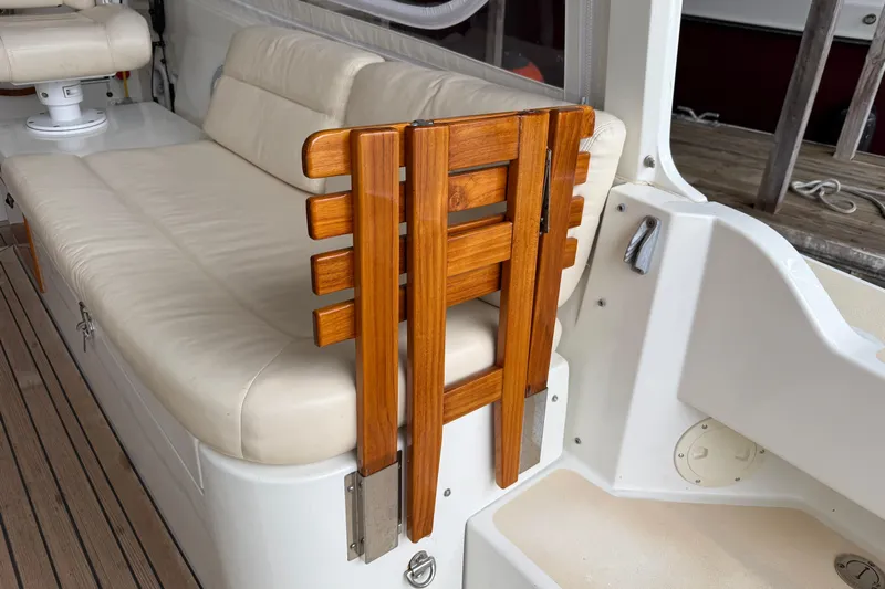 Kikiriki Yacht Photos Pics 2007 MJM 34z Downeast boat interior with beige seating and wooden folding table.