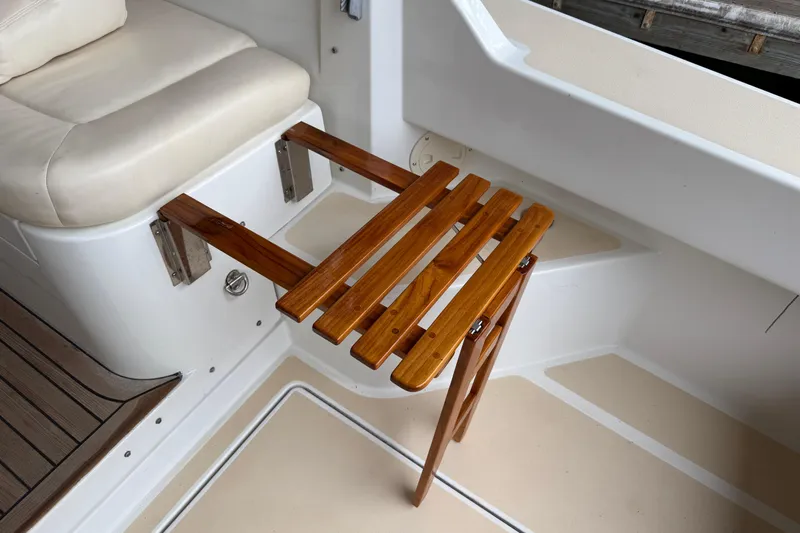Kikiriki Yacht Photos Pics Teak folding table on 2007 MJM 34z Downeast boat, next to cushioned seating.