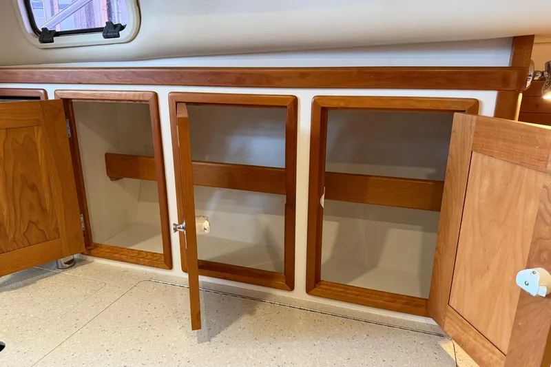 Kikiriki Yacht Photos Pics Open wooden cabinets inside a 2007 MJM 34z Downeast boat interior.