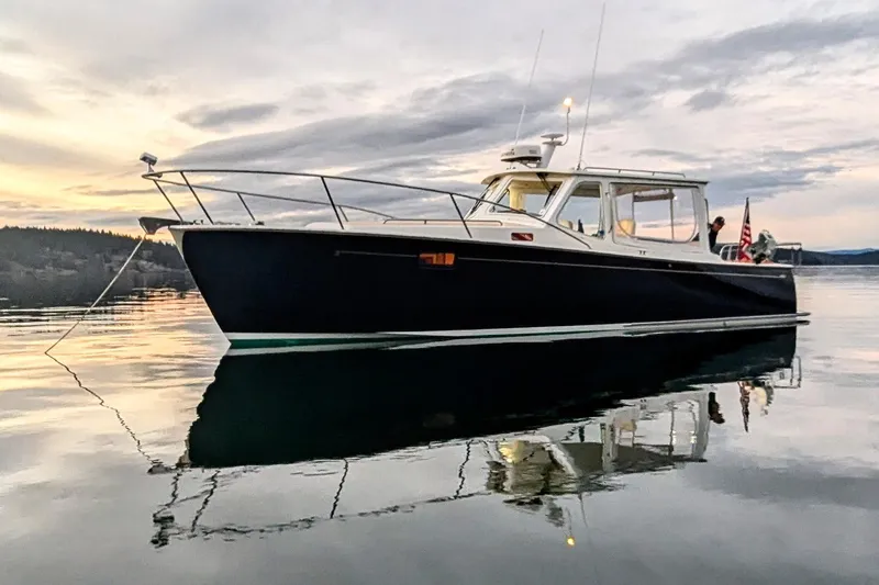 Kikiriki Yacht Photos Pics 2007 MJM 34z Downeast boat on calm water at sunset.