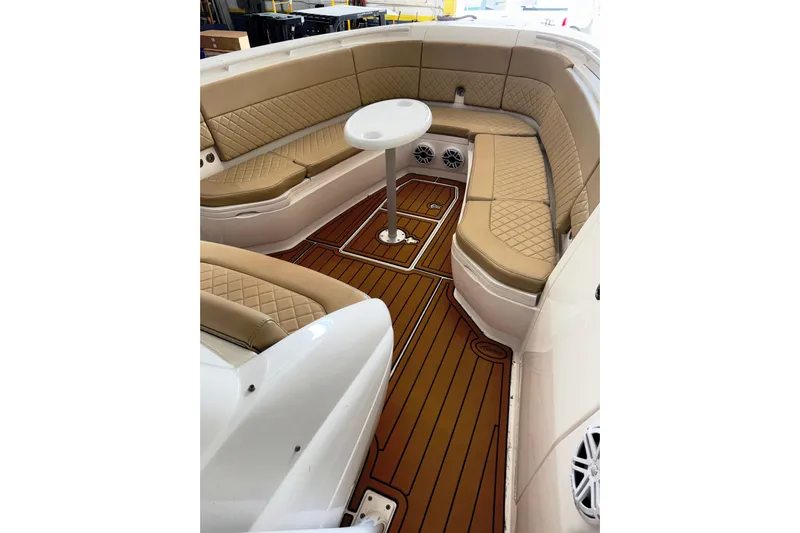 T/t Jodi Ann Yacht Photos Pics Luxurious seating area on 2019 Intrepid 345 Nomad FE boat with tan upholstery and wood flooring.