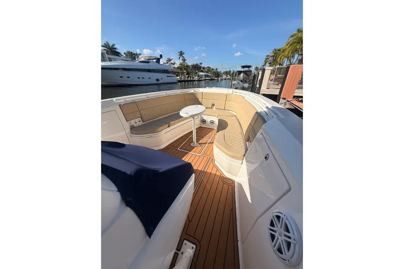 T/t Jodi Ann Yacht Photos Pics 2019 Intrepid 345 Nomad FE boat with elegant seating and teak flooring, docked under clear skies.