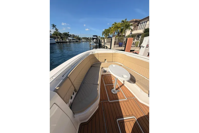 T/t Jodi Ann Yacht Photos Pics 2019 Intrepid 345 Nomad FE boat interior with tan seating and wooden deck.