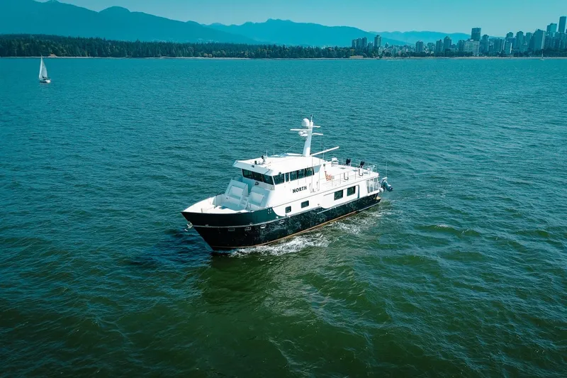 North Yacht Photos Pics A 2002 Darling Yachts Custom Aluminum yacht cruising near a city skyline.