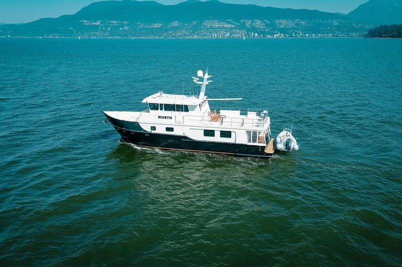 North Yacht Photos Pics A 2002 Darling Yachts Custom Aluminum yacht on open water with scenic mountain backdrop.