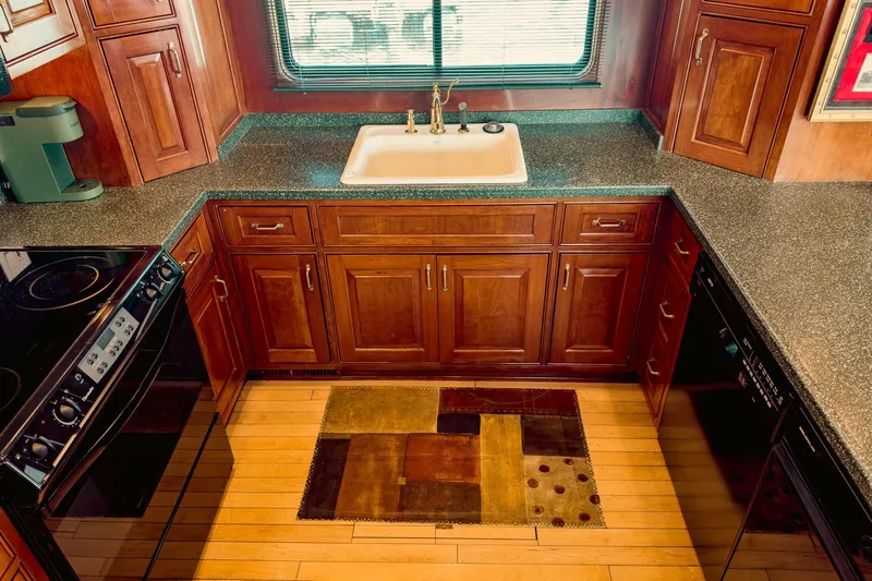 North Yacht Photos Pics Luxurious yacht kitchen with wooden cabinets, modern appliances, and a stylish rug, Darling Yachts 2002.
