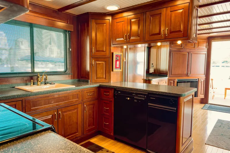 North Yacht Photos Pics Luxurious yacht kitchen with rich wood cabinetry, modern appliances, and ample natural light.