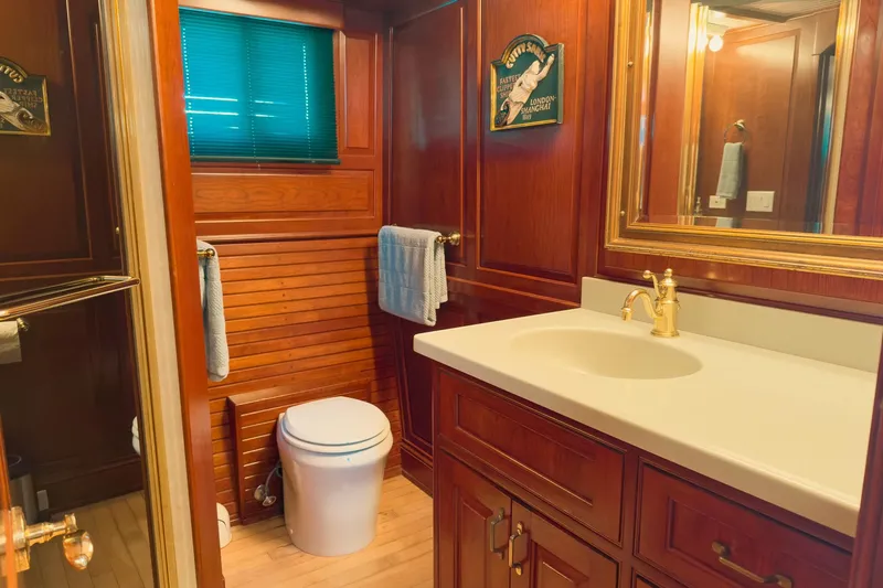 North Yacht Photos Pics Luxurious yacht bathroom with wooden cabinetry, gold fixtures, and a modern sink. Darling Yachts 2002.