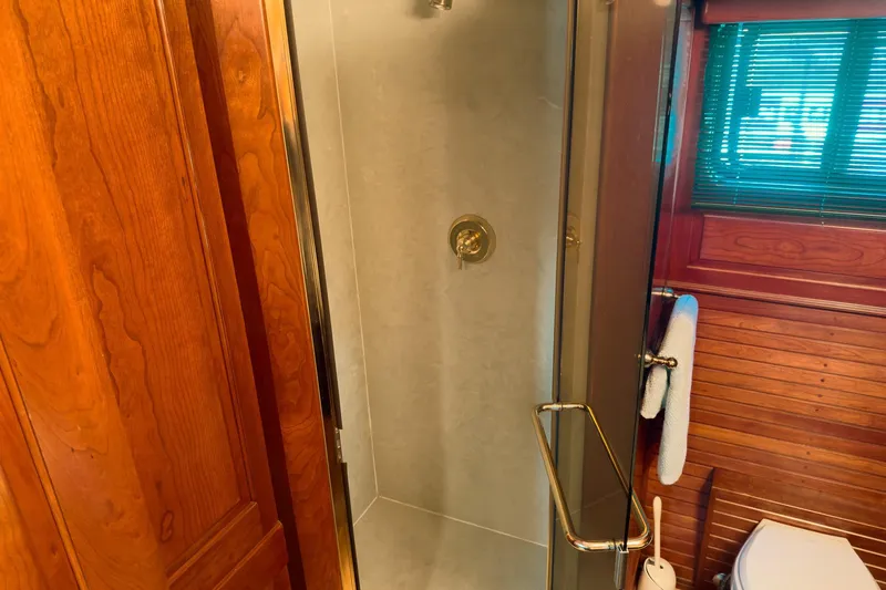 North Yacht Photos Pics Luxurious yacht bathroom with wooden accents, glass shower, and window blinds. Darling Yachts 2002 model.