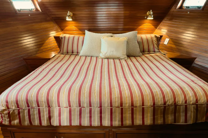 North Yacht Photos Pics Luxurious yacht bedroom with striped bedding, wooden walls, and ambient lighting. Darling Yachts Custom Aluminum, 2002.