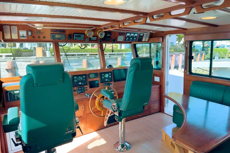 North Yacht Photos Pics Pilothouse interior of 2002 Darling Yachts Custom Aluminum, featuring green seats and wooden accents.