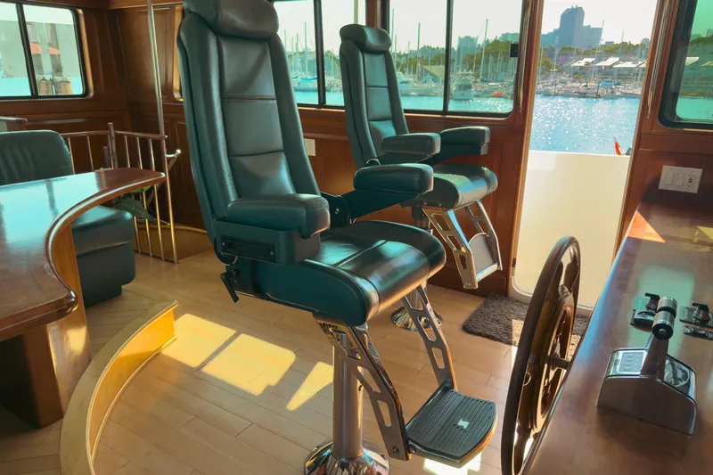 North Yacht Photos Pics Pilothouse interior of 2002 Darling Yachts Custom Aluminum, featuring leather chairs and helm.