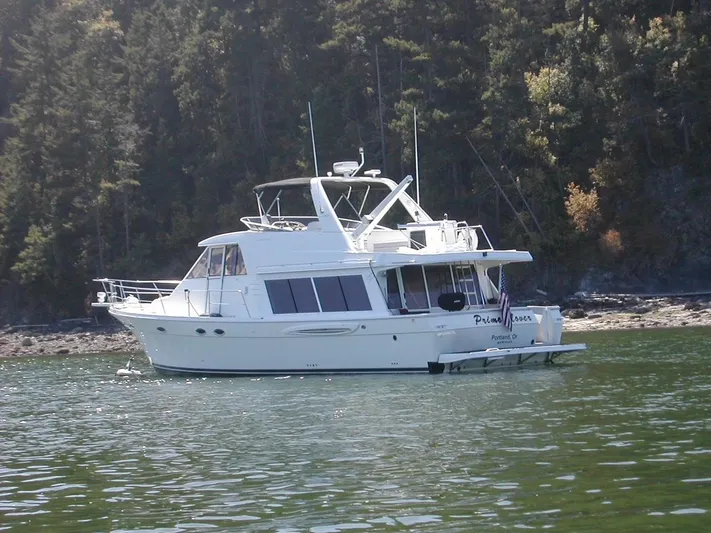  Yacht Photos Pics 2005 Meridian 490 Pilothouse yacht on calm water near forested shoreline.