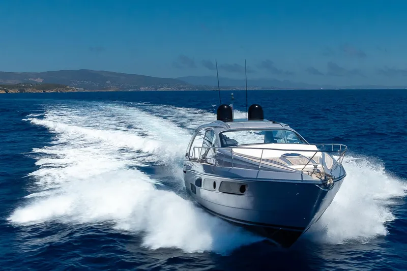 Polar Yacht Photos Pics 2023 Pershing 5x yacht cruising on open sea with mountainous backdrop.