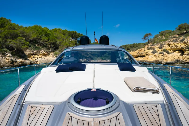 Polar Yacht Photos Pics 2023 Pershing 5x yacht anchored in clear turquoise waters, surrounded by lush greenery.