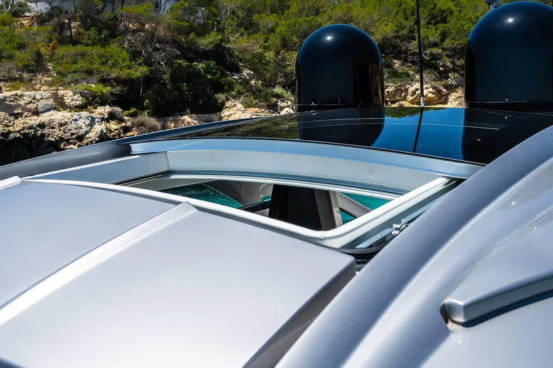 Polar Yacht Photos Pics 2023 Pershing 5x yacht with open sunroof, sleek design, and scenic background.